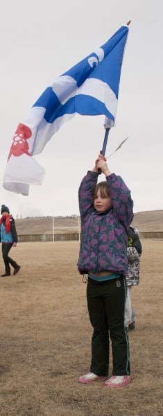 Seven-year-old Halena Paquet waves the Franco-Alberta flag at the future site of Ecole Notre Dame des Vallees during a breaking-ground ceremony March 15.