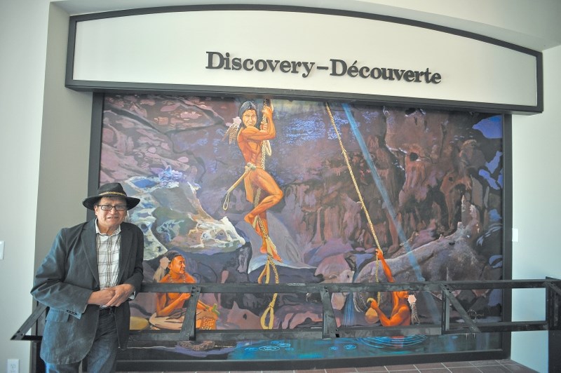 Stoney Nakoda First Nations artist Roland Rollinmud stands with his work at the Cave and Basin National Historic Site May 10. Following a two-year closure for renovations,