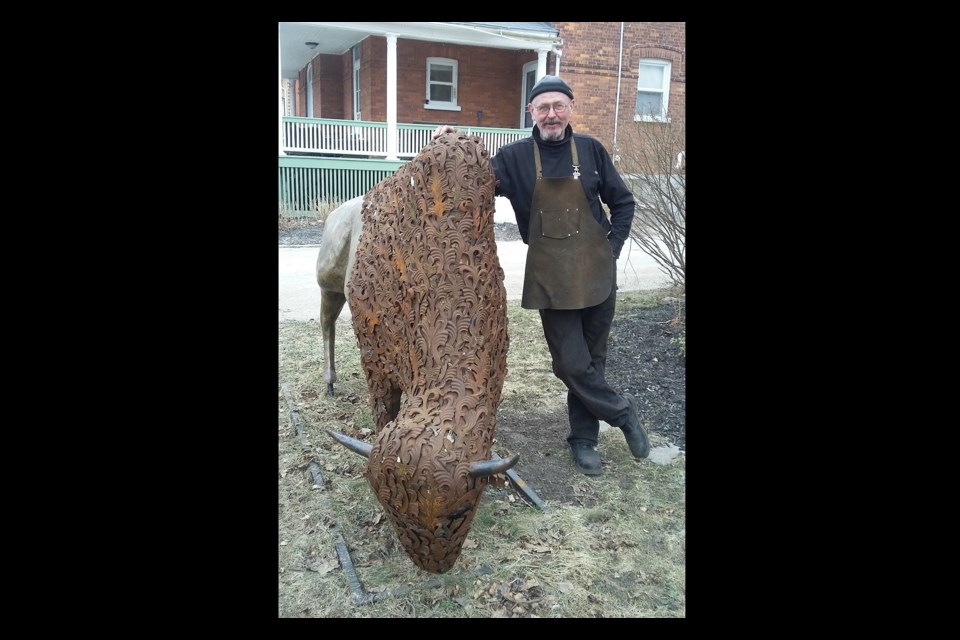 John McCaffrey stands with his bison sculpture at his home on Pine Street in Collingwood.