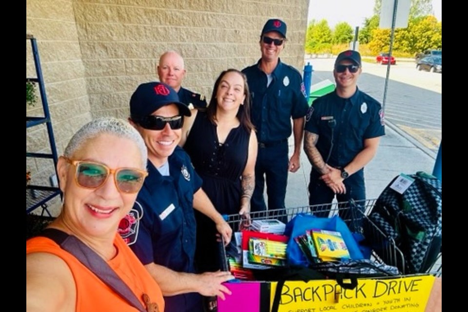 Ashley Plewes (centre) along with members of Collingwood Fire and local musician Marcia Hubbs all participated in one of numerous backpack drives that ran in Collingwood in August, to collect backpacks for kids in need.