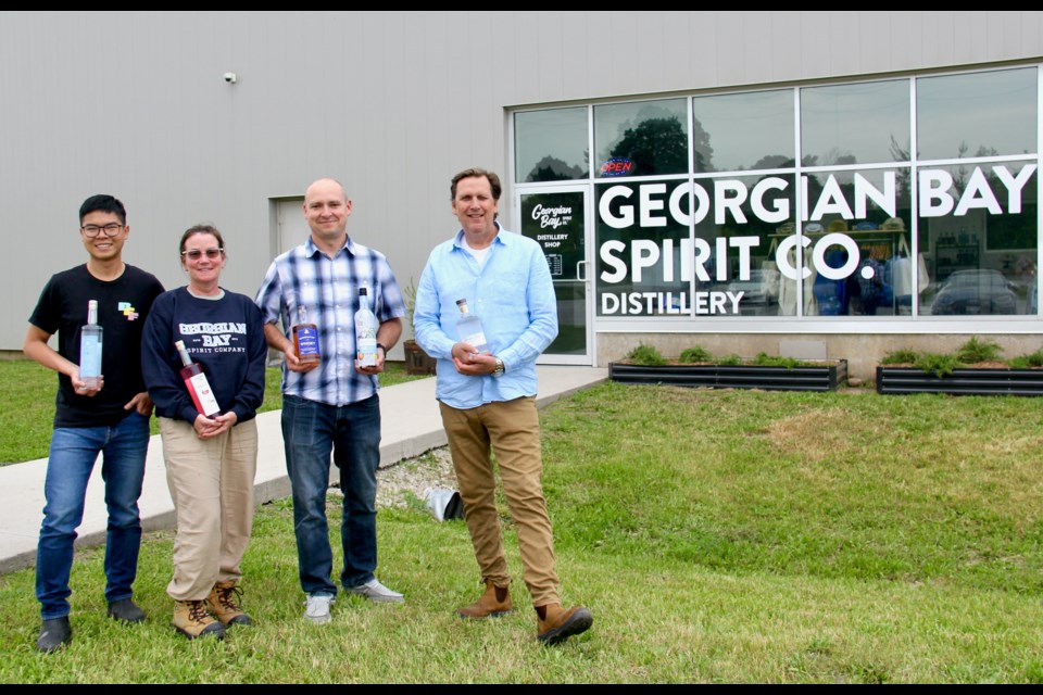 Georgian Bay Spirit Co. recently opened a retail shop at its 395 Raglan St. distillery in Collingwood. Tuan Dang, left, distillery specialist,  Tricia Boettcher, bottling line operator, Gary Bender, distillery manager, and Denzil Wadds, co-founder and co-owner are pictured.