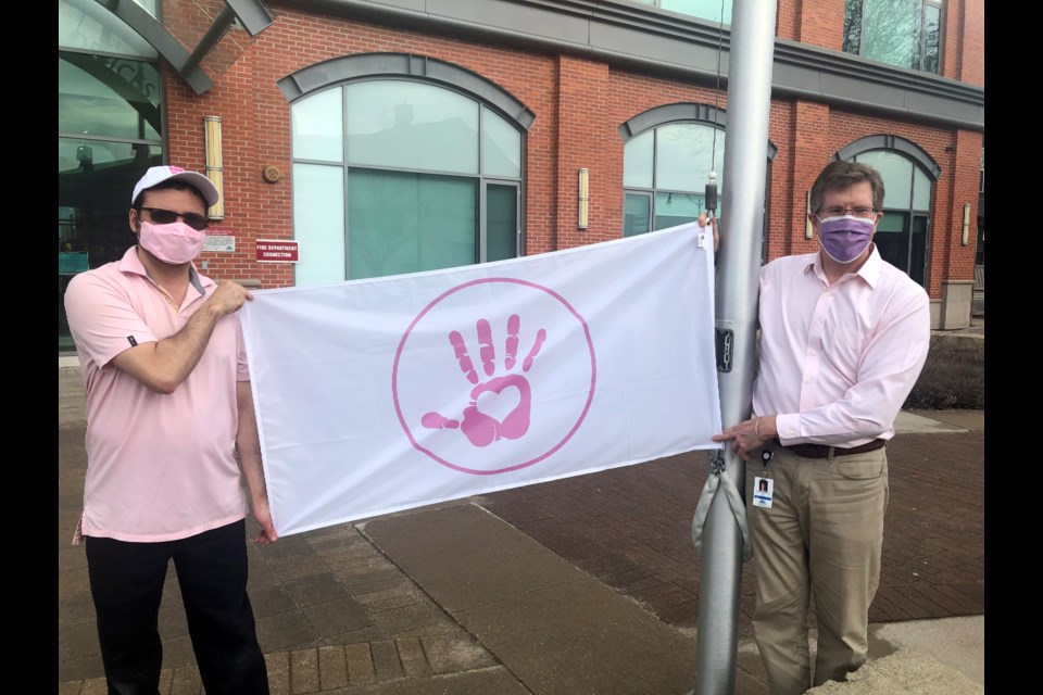 Trevor Henson and Mayor Brian Saunderson raise the flag for International Day of Pink on April 13, 2022. 