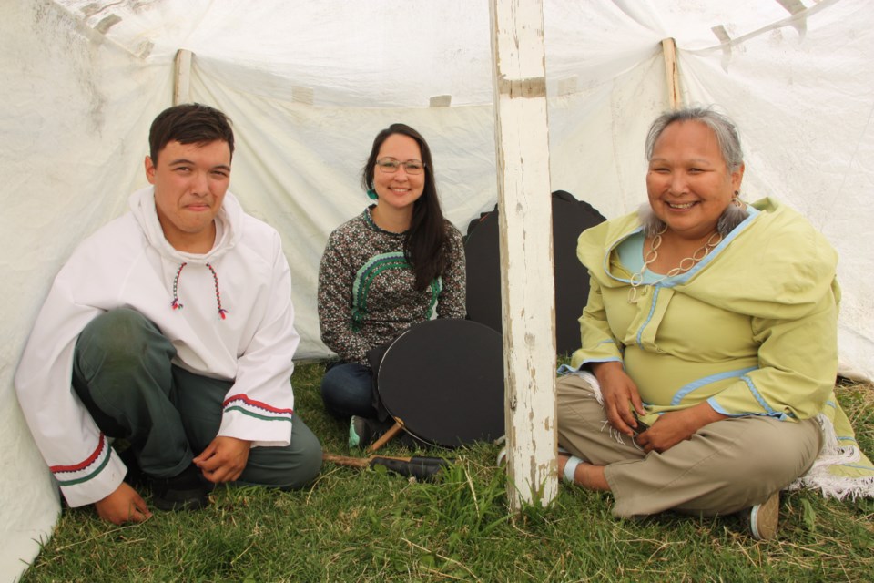 Aalpi Kimarluk, Muckpaloo Ipeelie, and Tauni Sheldon are sitting inside the tupiq (tent) used by Inuit hunters during the spring and summer months. 