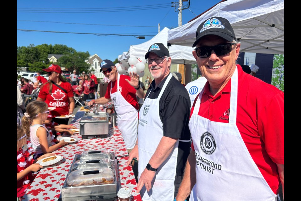 Town council members Coun. Steve Perry, Rob Ring and Deputy Mayor Tim Fryer serving pancakes and sausages for Canada Day in Collingwood July 1, 2024. 