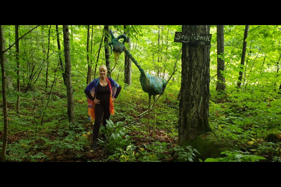 Marion Bartlett with one of the sculptures in her forest property. 