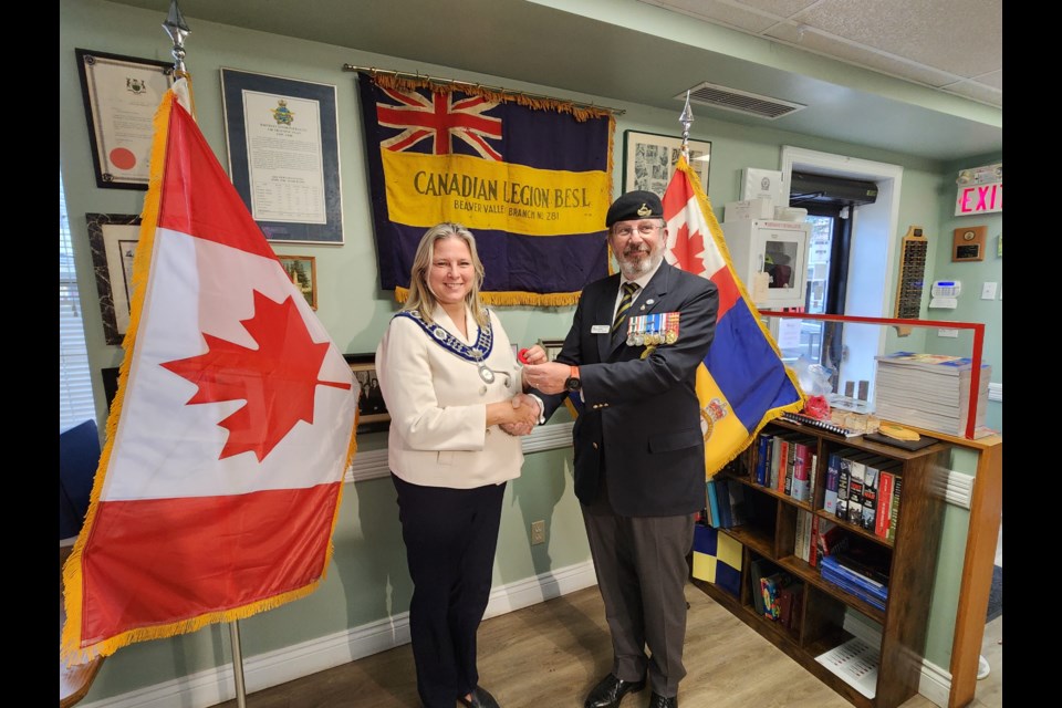 Royal Canadian Legion Branch 281 President Eobhann Bruce presents the official first poppy to The Blue Mountains Mayor Andrea Matrosovs.