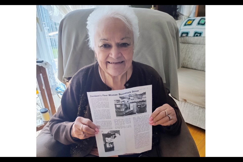 Linda Aelick, Denison Mines first female Boomtruck Operator, holds up a newspaper article written about her