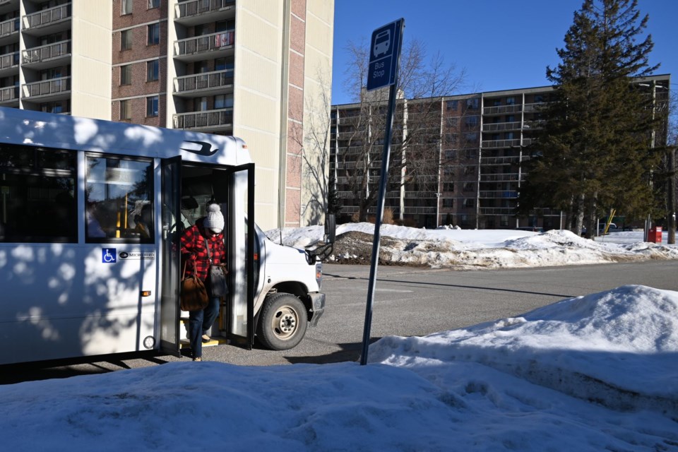 Passenger steps off bus at Washington Crescent bus stop as viewed from sidewalk. Feb. 2, 2024