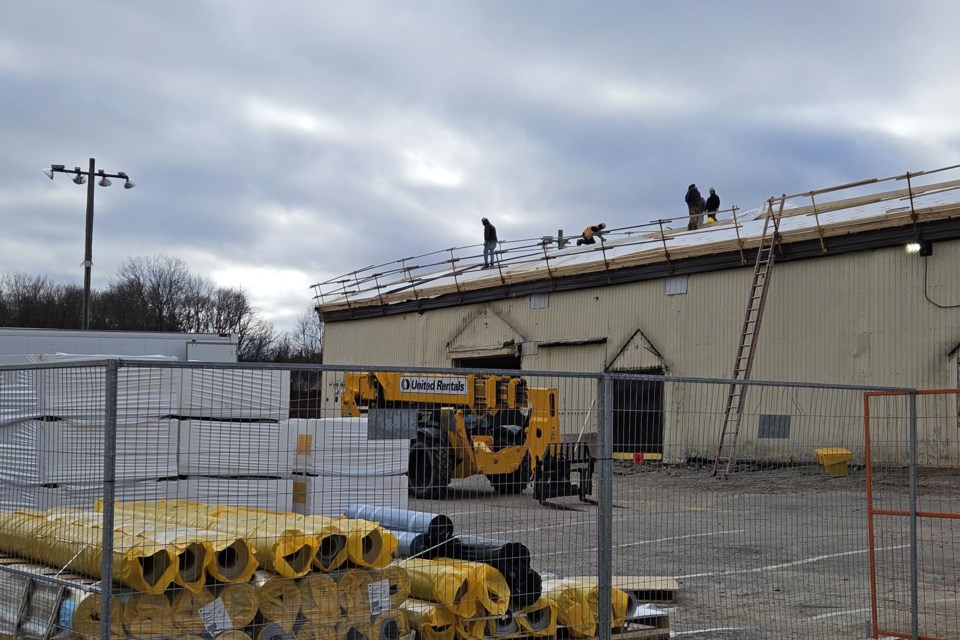 Roofing materials in foreground. Work underway on arena roof. Novemer 18, 2024