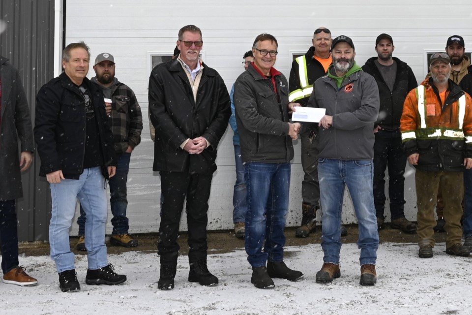 Scott Holmes, General Manager, Wendell Farquhar Trucking presents $50k to Deputy Mayor Flintoff for arena renovation. December 18, 2024