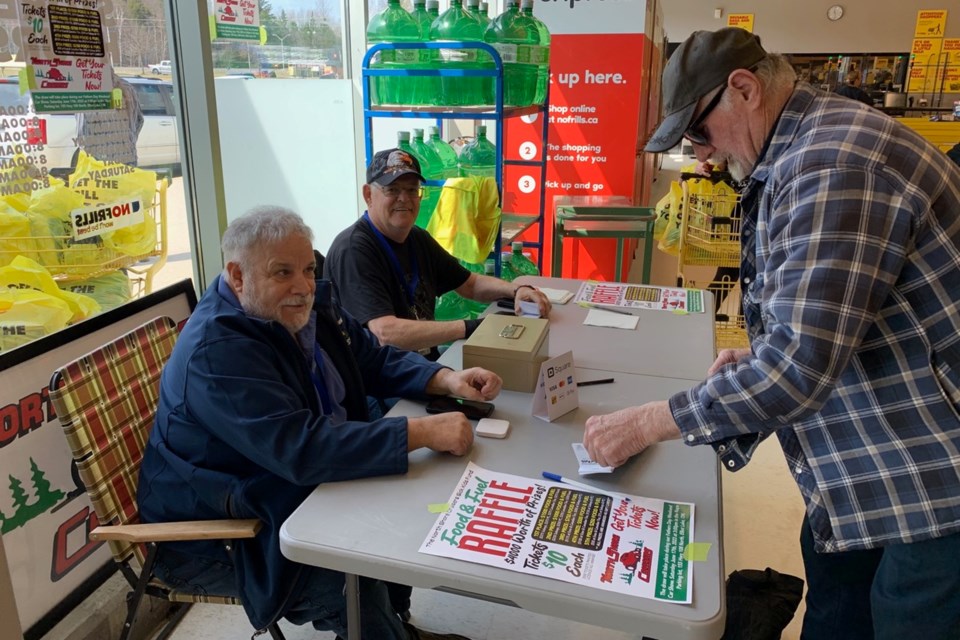 Ernie Grant of Cutler registers for the North Shore Cruisers raffle at No Frills on Friday. Cruisers president and 30-year member Denis Villeneuve (left) and fundraiser Leo Deveau assisted with the fundraiser. 