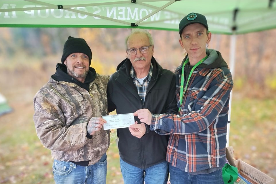 Danny Taphorn (left) accepts a $1,000 donation on behalf of Larry’s Place from local resident Guy Ward, along with Cody Pawliuk (right) a staff member of the men’s shelter. 