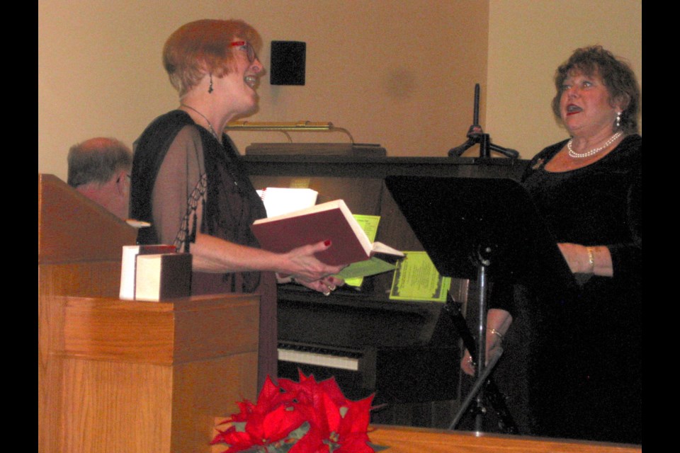 Christmas Cantata organizer and conductor Ann Foy, left, gets in tune with member Kathy Mitchell. Kris Svela for ElliotLakeToday