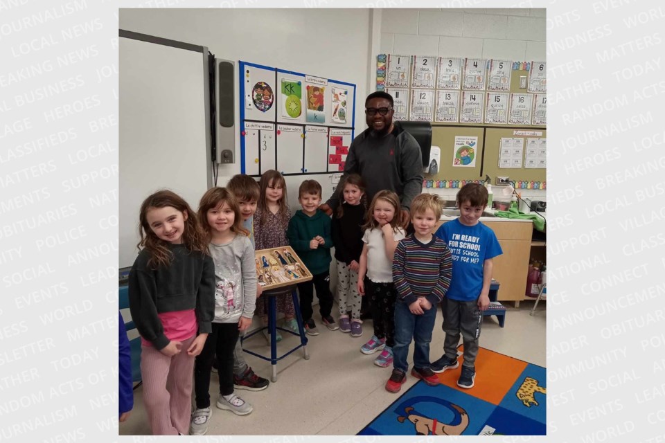 Grade one, Junior and Senior Kindergarten students with Father Patrick.