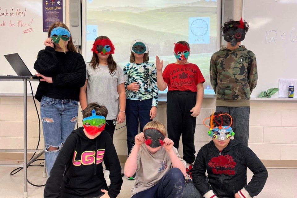 Students show off masks made in drama class