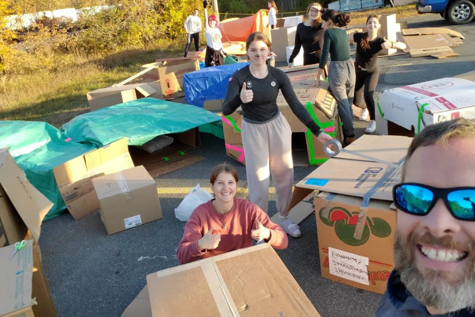 Students spend the night in shelters made from tarps and cardboard boxes.