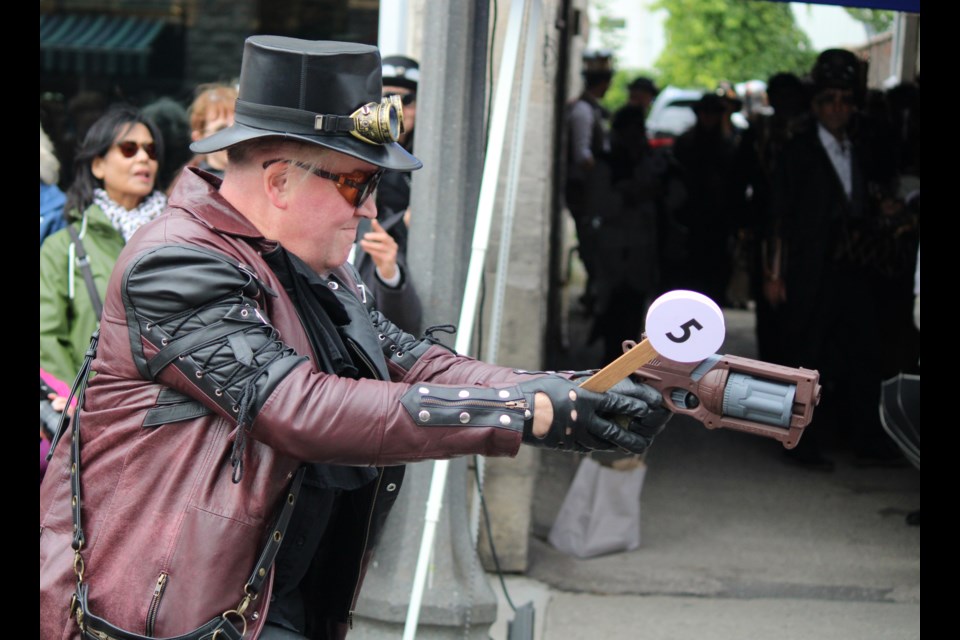 Showing off the costume and weaponry at the 2024 Fergus Steampunk fashion show.