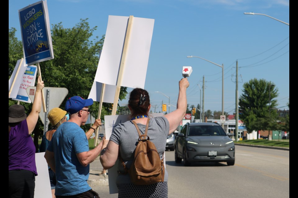 Picketers react to passing cars on St. David Street in Fergus Friday morning.