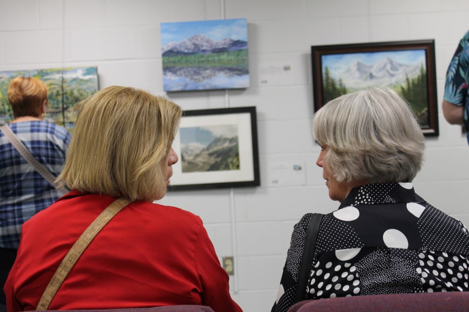 Betty Beaudoin of Stoney Creek and Linda Walker of Perth chat and admire the art at the Exhbition No. 4 opening on Thursday.