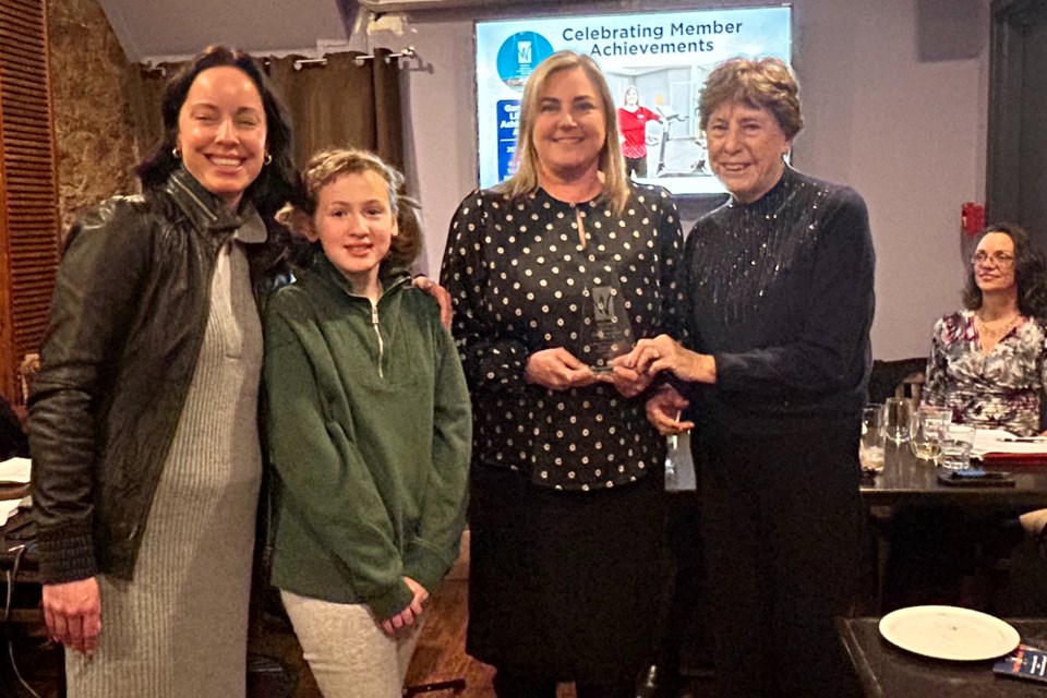 Amber Kosubovich (second from right) of Waterdown Physiotherapy accepts the Gary Titley Lifetime Achievement Award from members of his family, (from left) daughter Melinda, granddaughter Zoey and wife Bev (right).