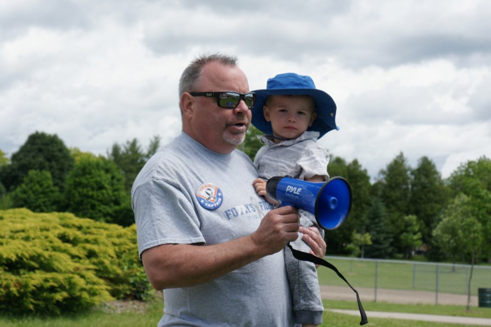 Jeff Foster and little Gryphon Ellis give opening-remarks at the start of the Fozzy's Fight Walk in Memorial Park Sunday.