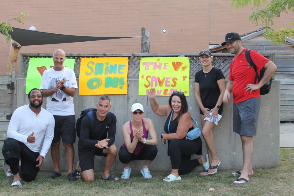 (Left to right) Masauni Masauni, Paul Haddad, Manny Figueiredo, Robin Abbott, Genevieve Hladysh, Kelly Frapporti-Tobin and Joshua Austin celebrate completing the first leg of The Long Walk Home Friday evening. (Not pictured: Pete Wisner). The group will hit the road again Saturday. 