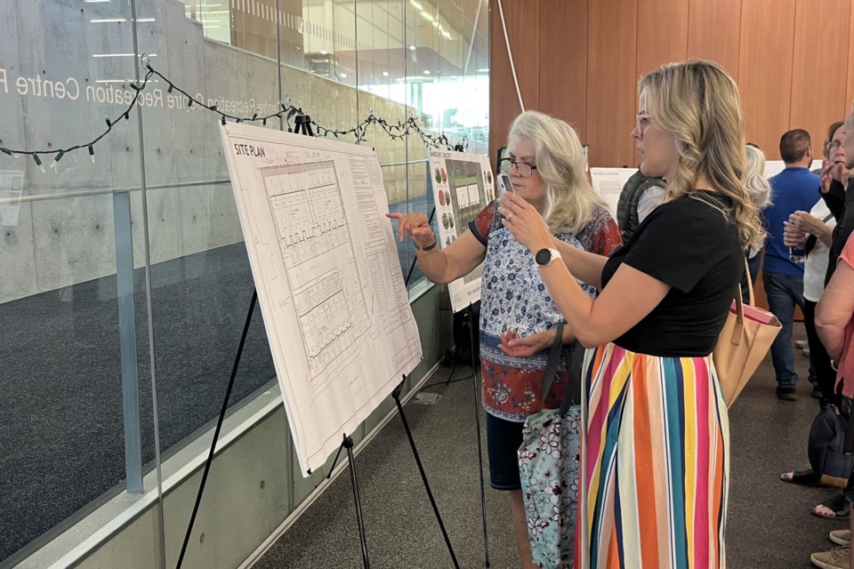 Stephanie Card and fellow neighbour to the proposed development, Mary Ann Martell, look at blueprints for the planned townhouse complex. 