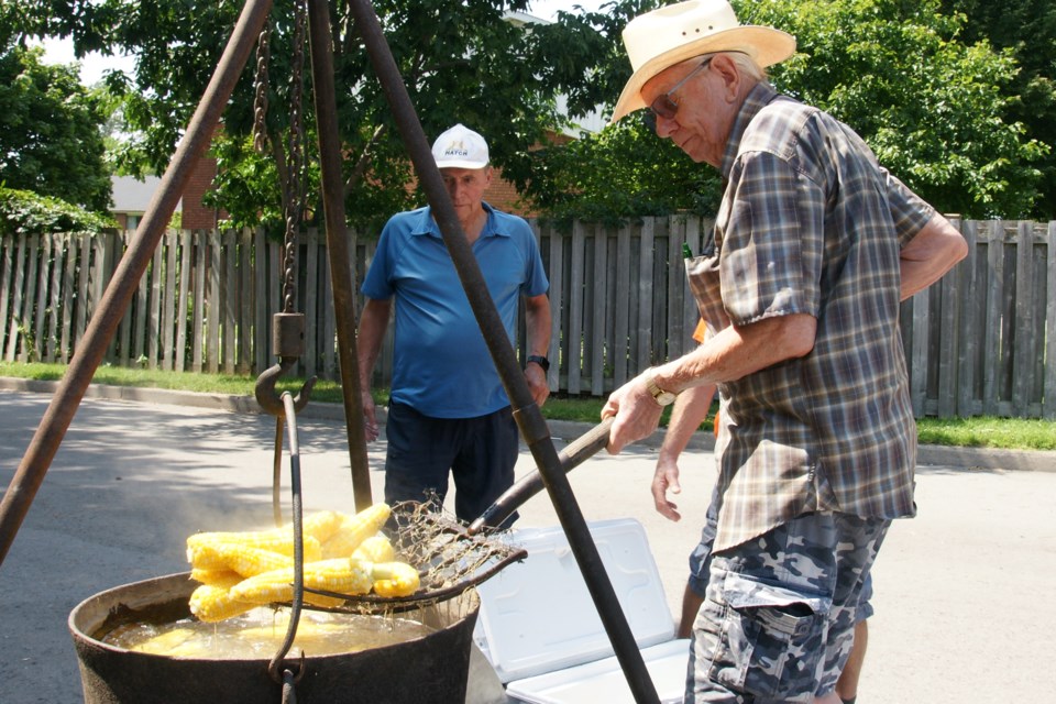 Cliff Bramhall lift some corn out of the pot as Dino Ribli looks on at the Waterdown Legion Sunday afternoon. 