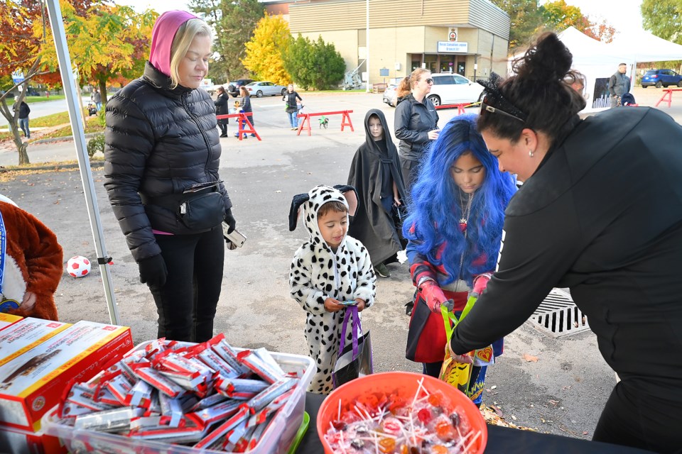 Julia Fahey of the Flamboro-Dundas Soccer Club hands out candy and granola bars to Julia and Max in downtown Waterdown Saturday.