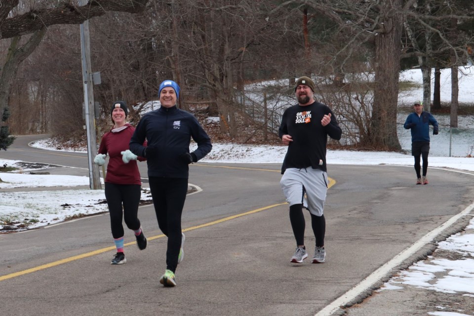 Jason Bainbridge, center, with Kirstin Lukasko to his left,  and Thomson Davie and Steve Forrest to his right. The four runners finish the final lap before returning to the rest of the group for a coffee. 