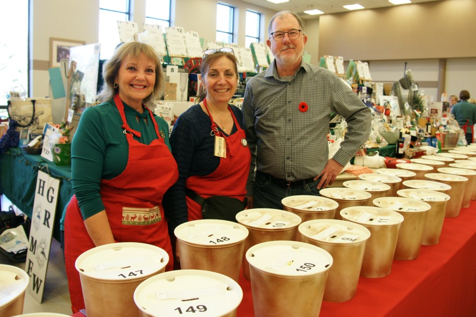 (Left to right)  Christine Nelson, penny sale organizer Domenica Brennan  event organizers Ron MacKenzie staff the penny sale table at the St. Thomas Holly Berry Bazaar Saturday morning.