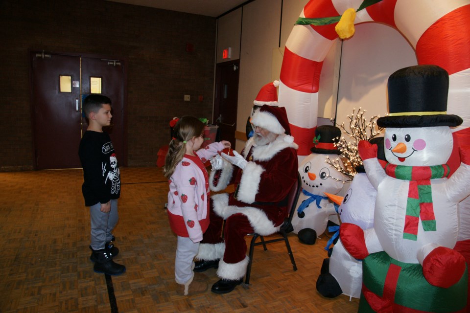 Addy, 8, and Alex, 10, visit with Santa during the Winterdown festivities at the Waterdown Legion on Saturday.