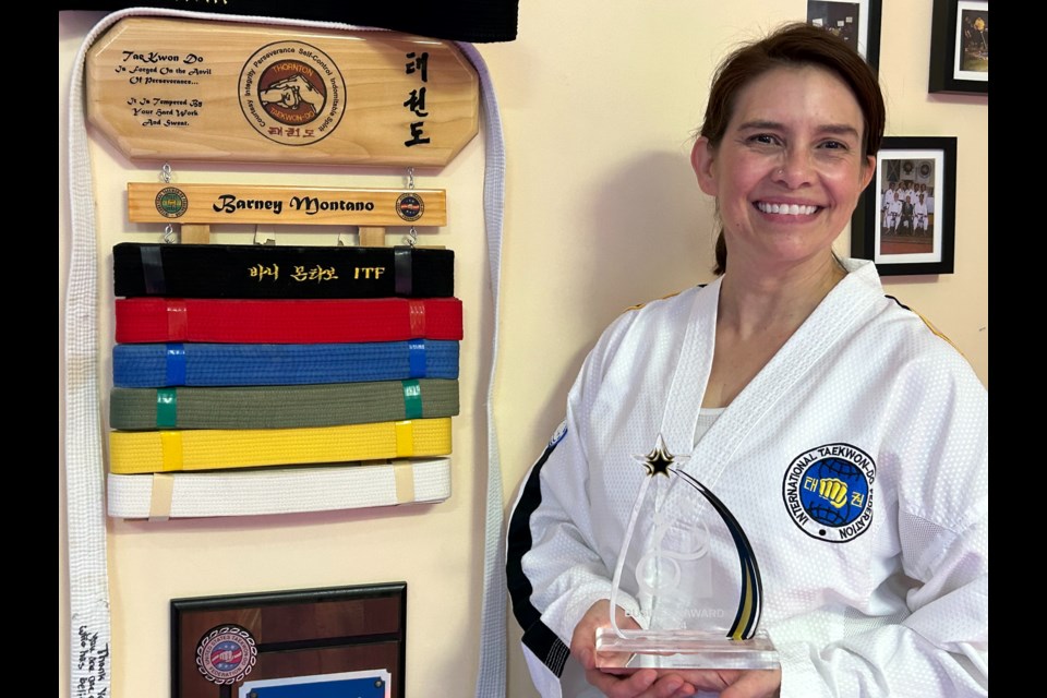 Rebecca Montaño with her Accessibility Trailblazer Award and her dad's belts.