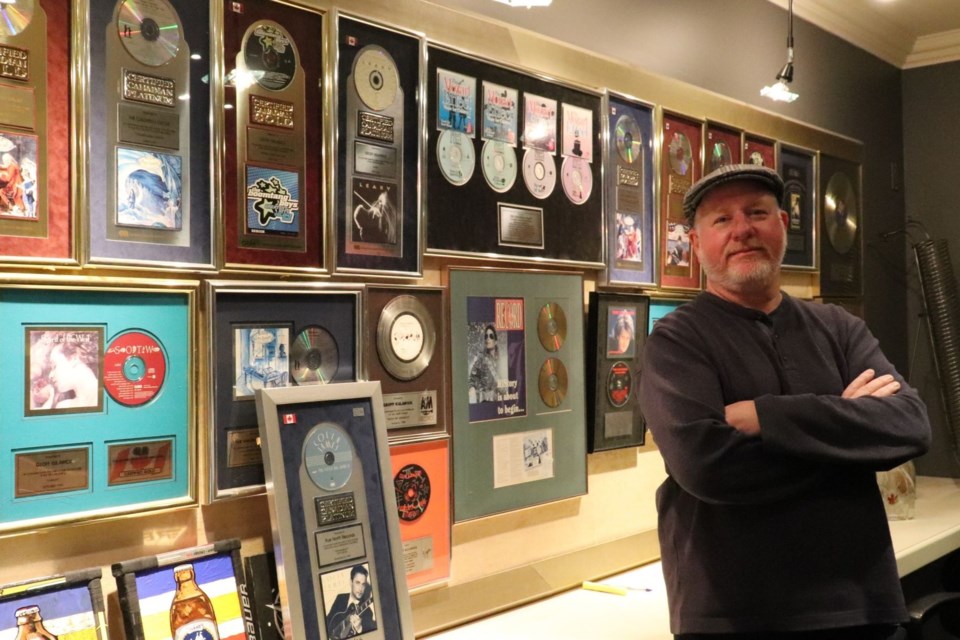 Geoff Kulawick with a small fraction of the gold and platinum records his company, Linus Entertainment, has garnered over the years. 