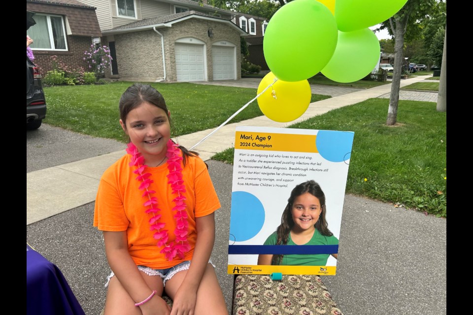 Mori Freitag poses with her McMaster Children's Hospital patient ambassador poster.