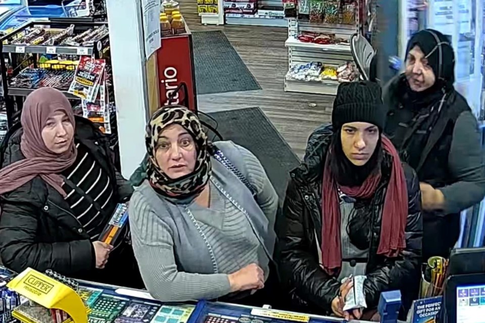 A photo of four of the women suspected of robbing Millgrove Community Store, standing at the store's counter as they distracted the owner. 