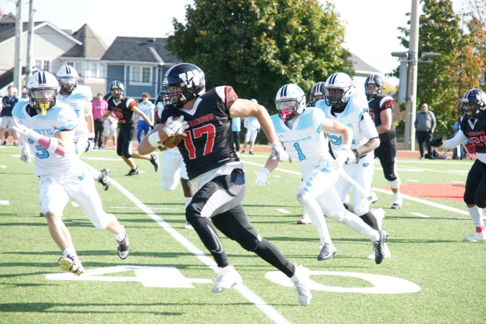 Warrior Jack Milum runs the ball with Westmount players in pursuit during Thursday's game.