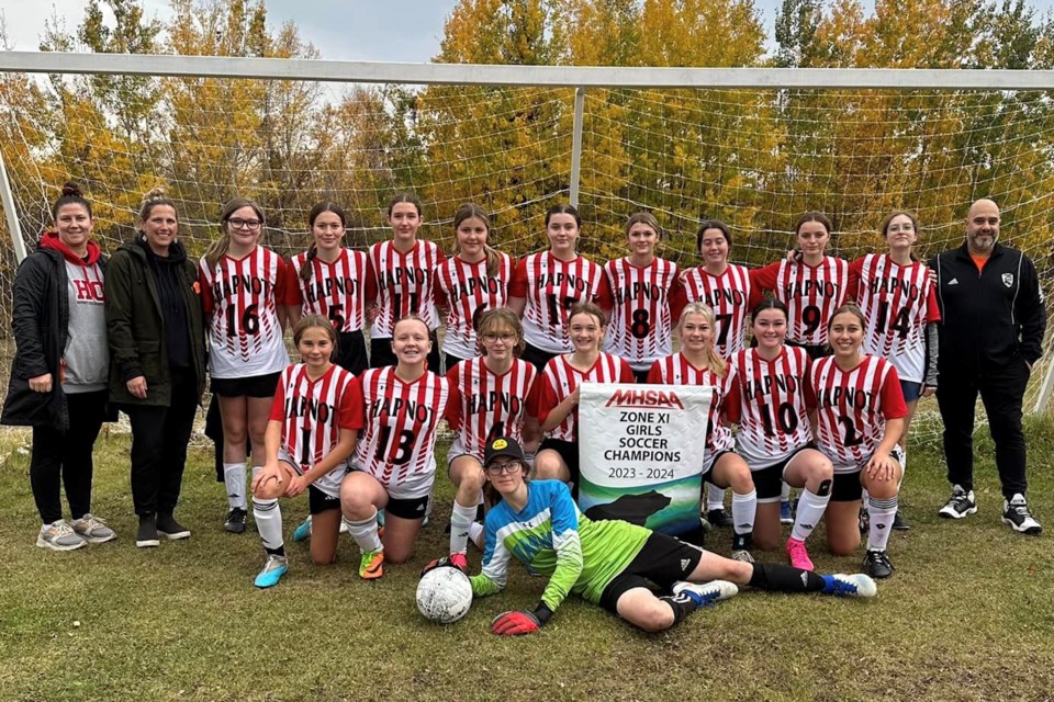 The Hapnot Kings and Kweens soccer teams hold up their newly-won Zone 11 championship banners following the zone tournament Sept. 29. Both teams made it through zones without conceding a single goal, qualifying for provincials in Dauphin later this month.