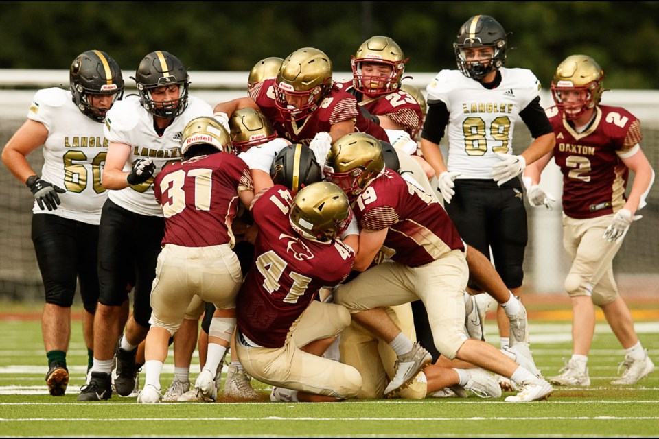 The Oakton defense squeezes and brings down Langley runningback Robert Ronskevitz.