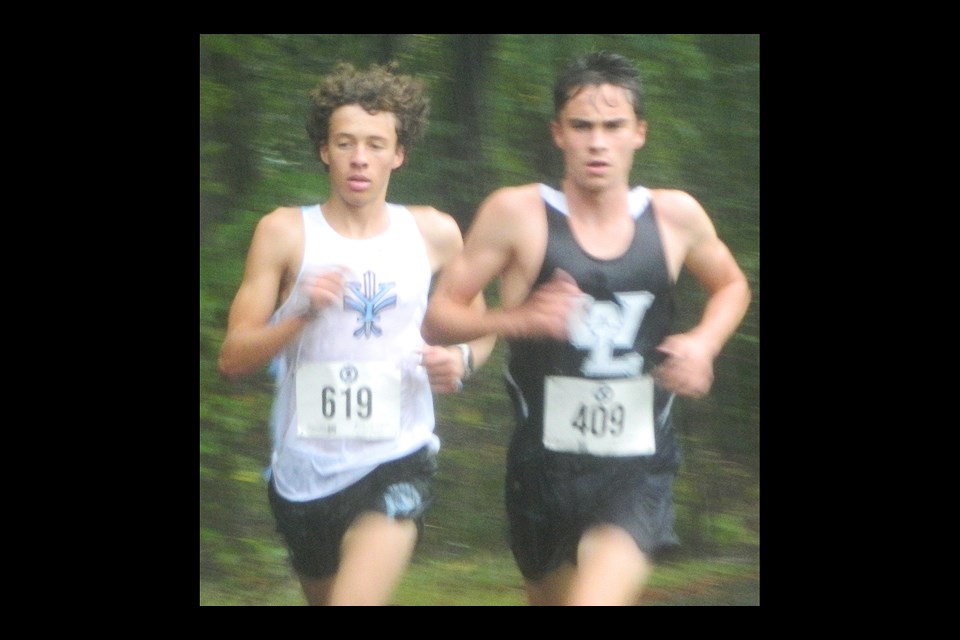 Yorktown's Reid Dalley, left, Washington-Liberty's Emmett Engelhardt take the lead early in the rainy and foggy boys Arlington County cross country meet. Dalley, the defending champion, finished second in the race and Engelhardt won.