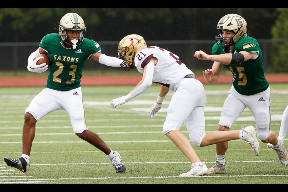 Langley’s Ellington Roane stiff arms Oakton’s Connor Tapp as Langley’s Robert Roncskevitz comes up to block.