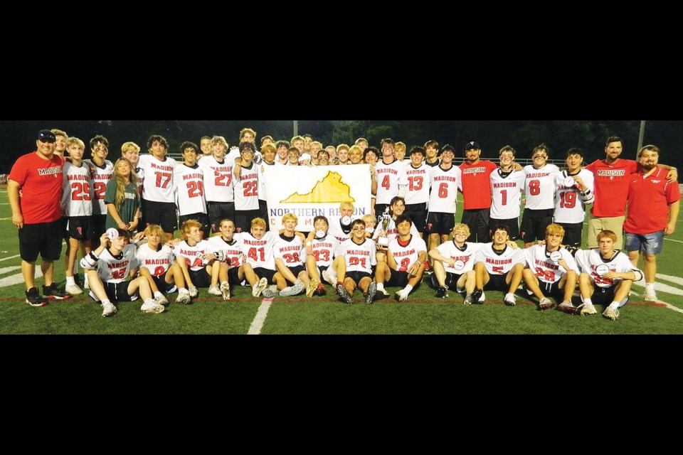 The Madison Warhawks gather with the championship banner and trophy after winning the 6D North Region boys lacrosse team on their home field. [Photo by Dave Facinoli]