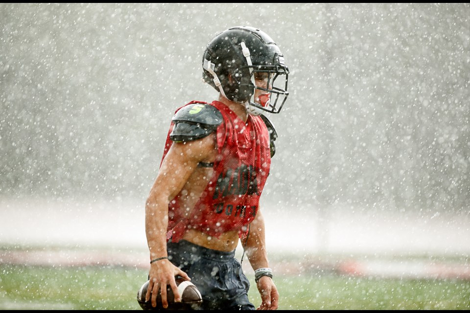 A wet Cord Yates returns to the huddle with the ball.