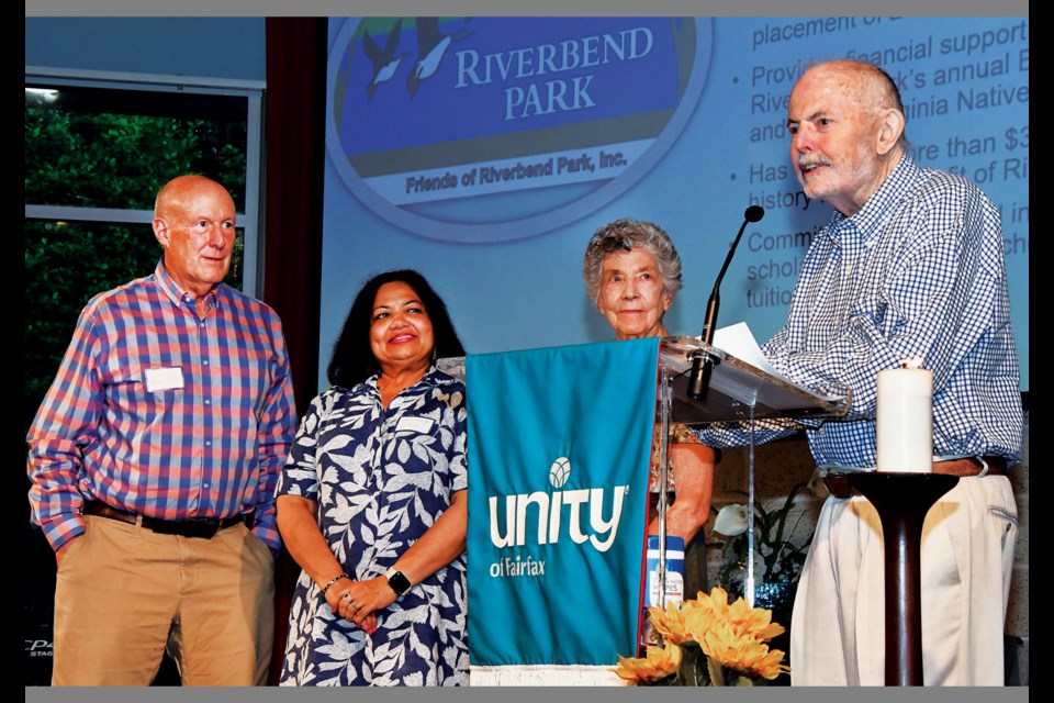 Friends of Riverbend Park members John Hughes-Caley, Ahalya Sharma and Eleanor Anderson listen as the group's president, Hugh Morrow, accepts a Sustainability Champions Award from Faith Alliance for Climate Solutions during a June 6, 2024, ceremony at Unity of Fairfax in Oakton. 