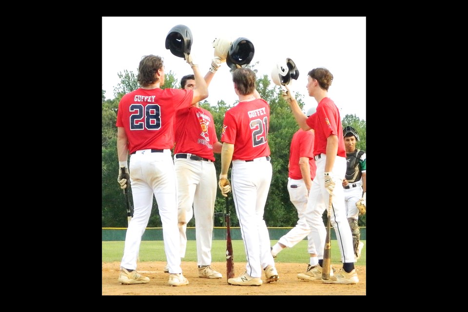 Thomas Koomey, second from left, clanks helmets with some of his Arlington Post 1995 teammates after homering early in an opening-round district tournament game.