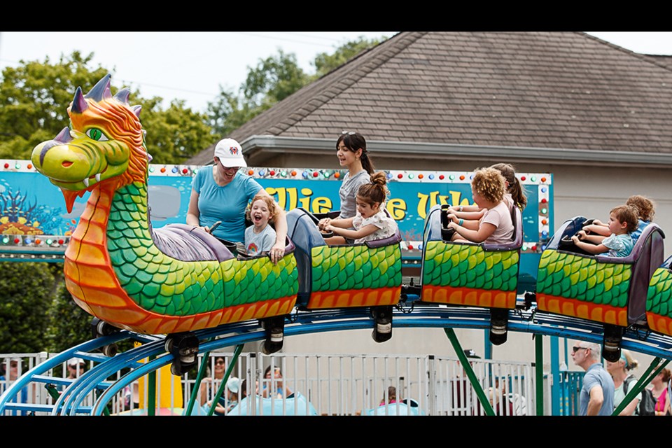 Roller coaster  riders Ronak Rhoden and her daughter Valerie enjoyed the scenic front seats in the colorful dragon roller coaster at the 2024 ViVa! Vienna! celebration.