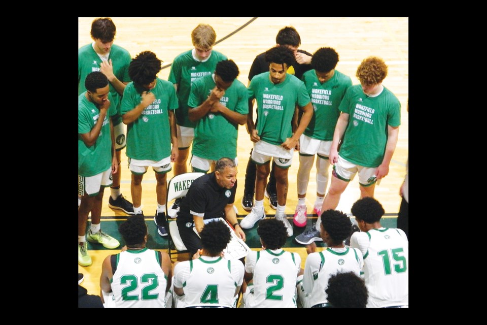 Wakefield High School head boys basketball coach Tony Bentley talks to his players during a timeout in a semifinal game of the George Long Holiday Hoops Tournament. 