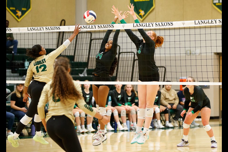 Wakefield's Mackenzie Williams and Ella Courtney try to block a kill attempt by Langley's Ava Barnett. 