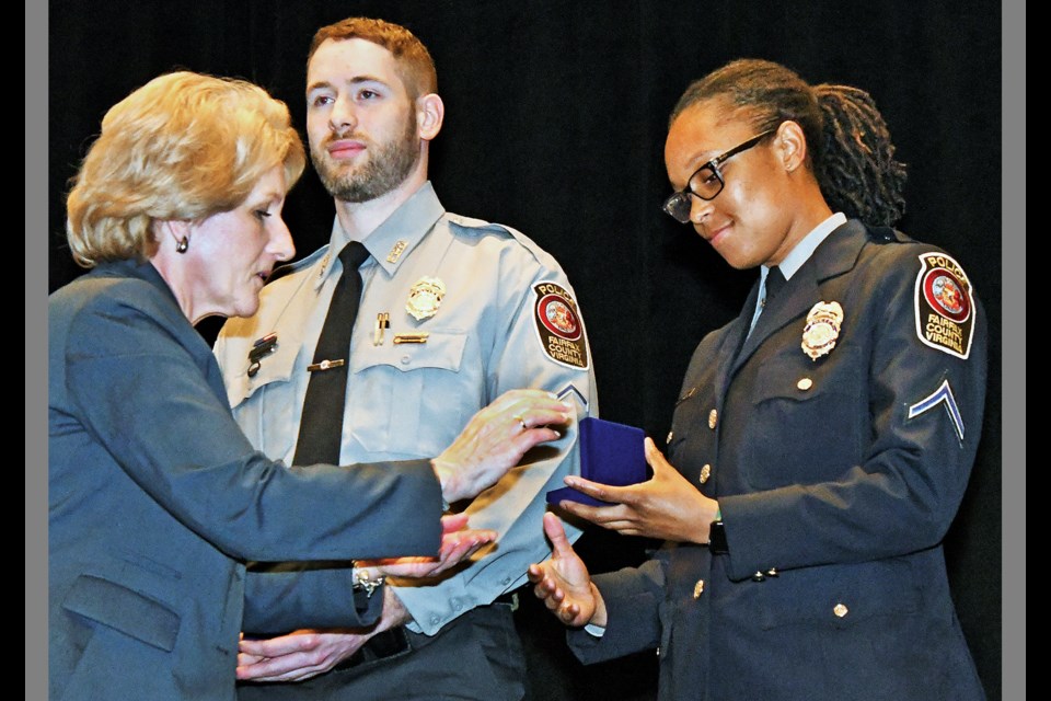 Deborah Fulbrook of Inova presents a Silver Medal of Valor to Fairfax County police Pfc. Alec Lamp and a Bronze Medal of Valor to Officer Shantelle Jennings on March 30 at the 45th Annual Fairfax County Valor Awards, held at the Hyatt Regency Reston. (Photo by Brian Trompeter)