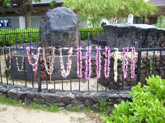 Visitors pay respect to the sacred Stones of Kapaemahu, located on Kuhio Beach in Waikiki, by leaving colourful leis.